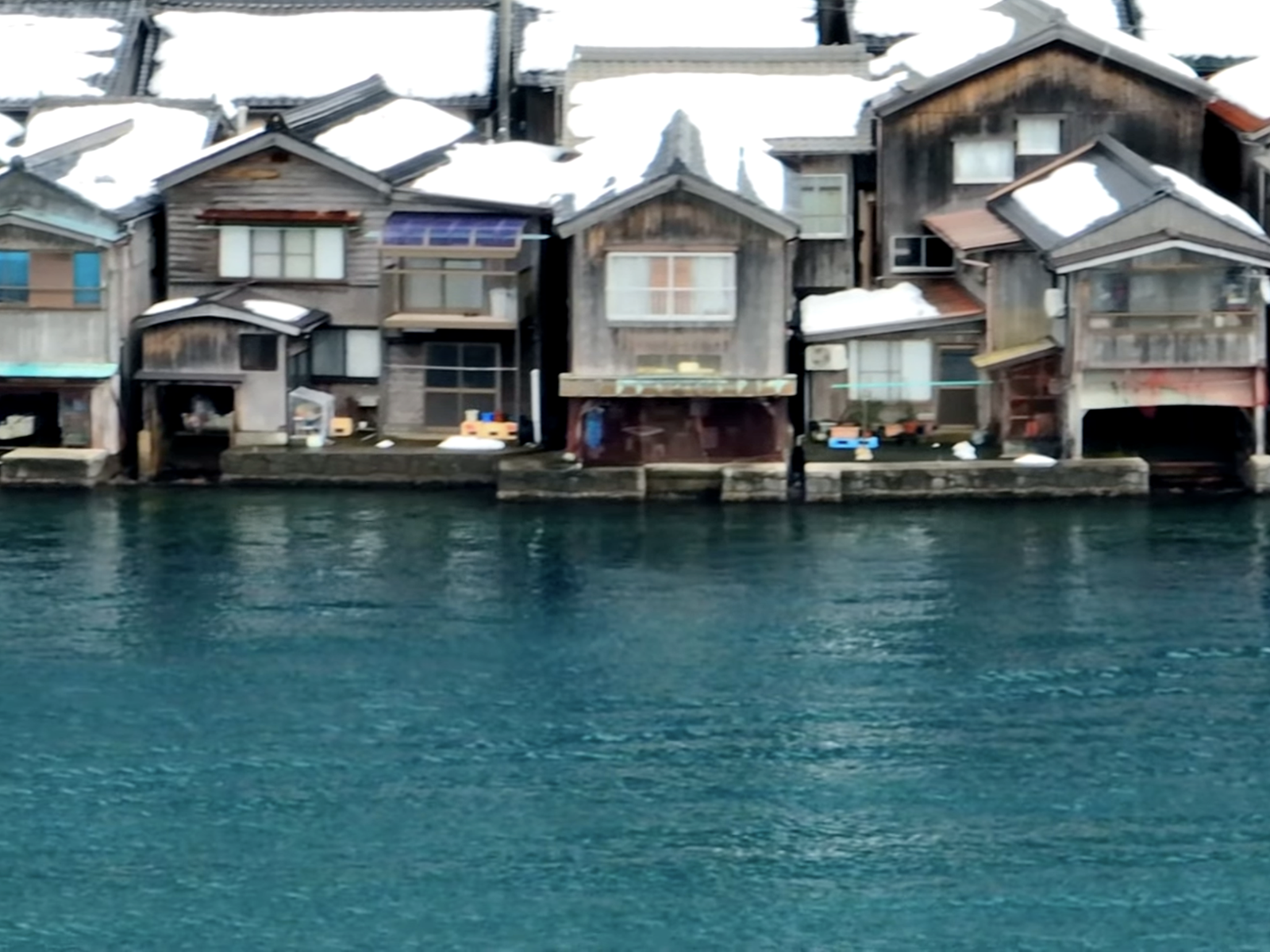 雪の伊根舟屋と青い海